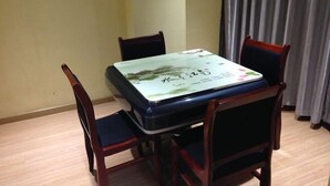 A dining table with a floral tablecloth, surrounded by four wooden chairs.
