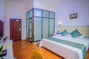 A hotel room with a bed, a desk, a chair, a wardrobe, and a door. - Meizhou Island Haifengting Residential Residence (Putian)