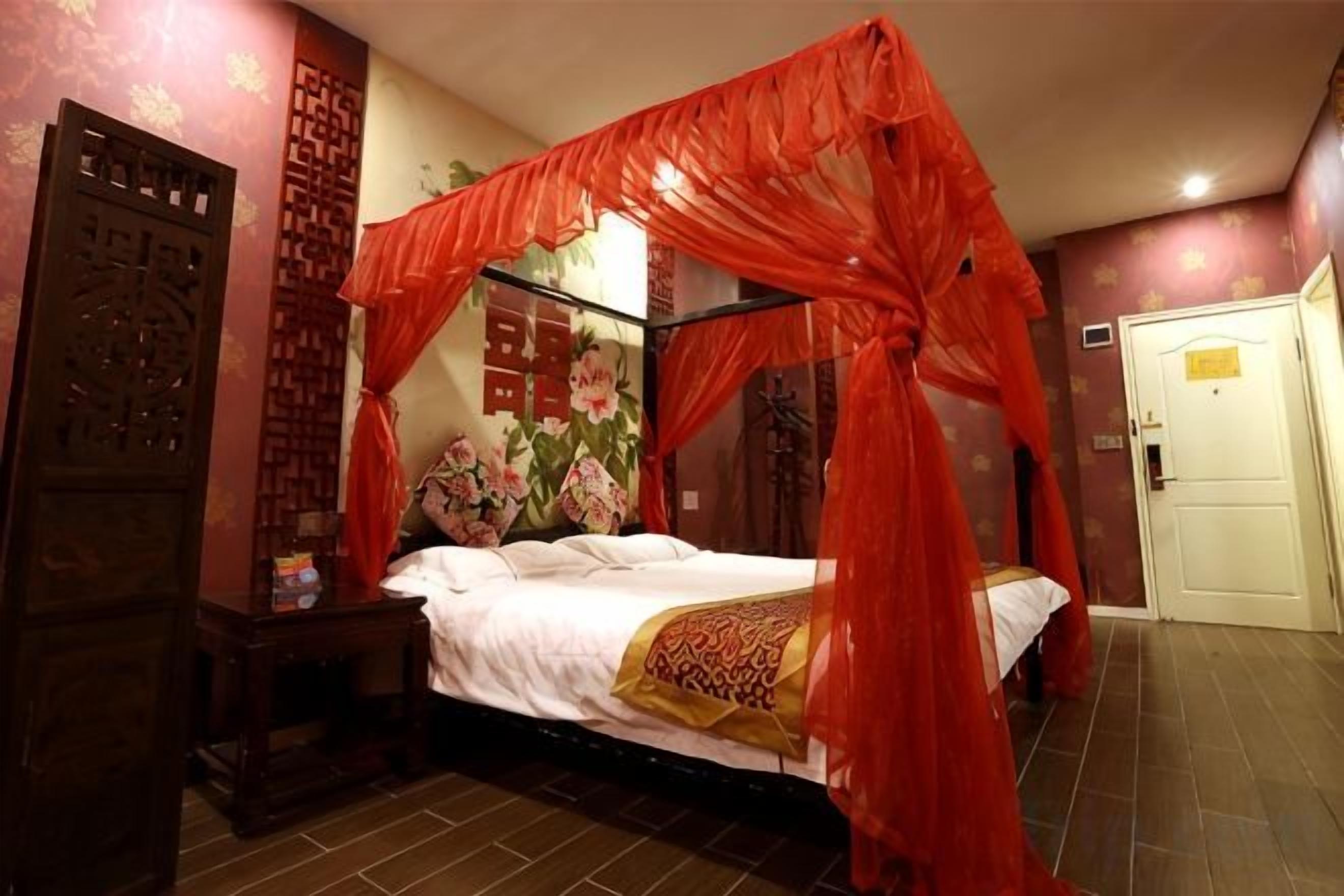 Una habitación con cama con dosel, un armario de madera y una puerta.