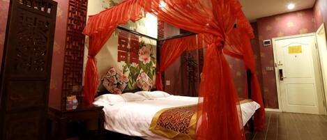 Una habitación con cama con dosel, un armario de madera y una puerta.