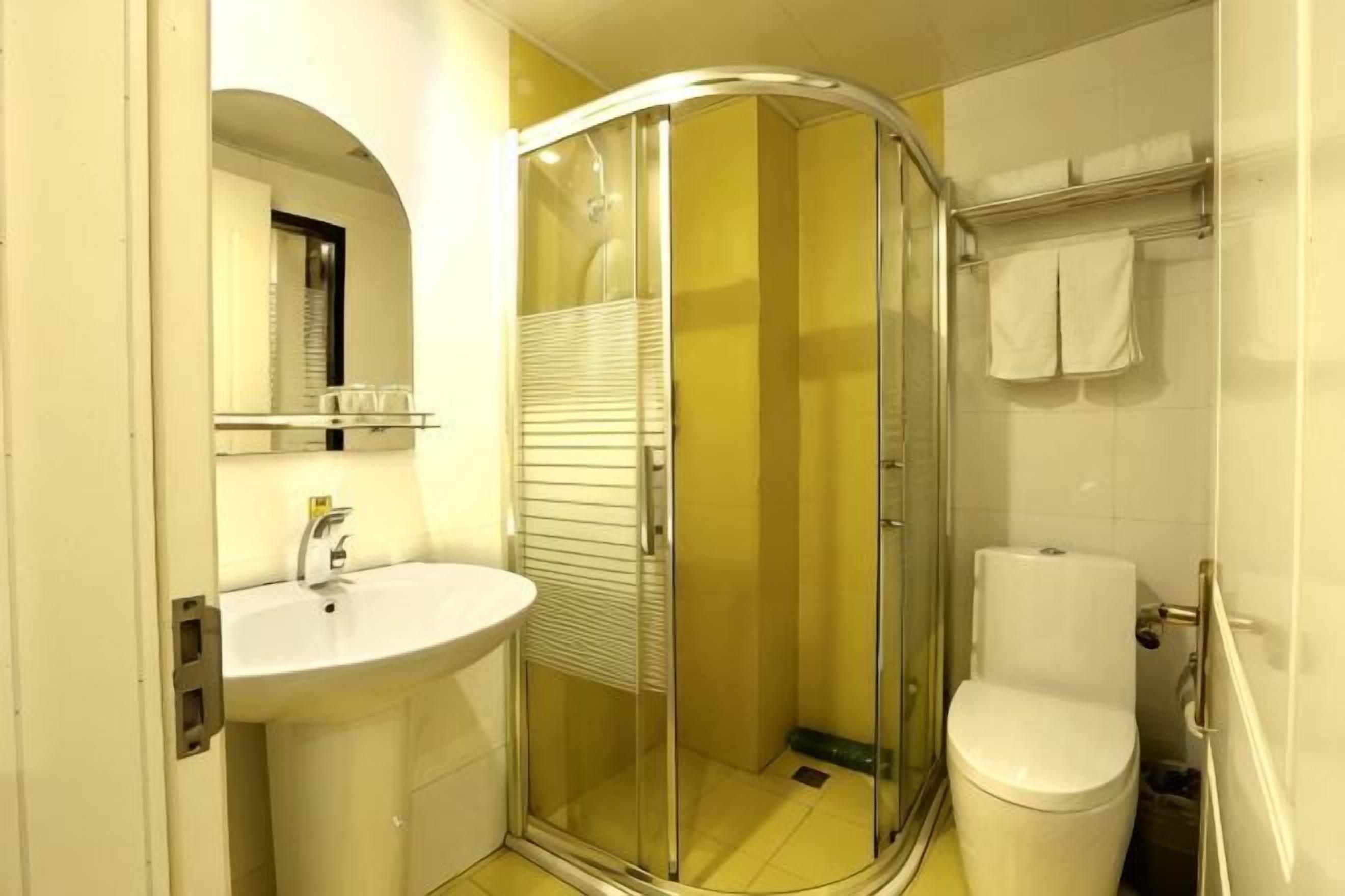 A bathroom with a glass shower enclosure, a sink, and a toilet.