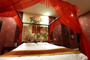 A bed with a canopy, a wall with floral wallpaper, and a traditional Chinese decorative screen. - Xinhuamian Fashion Hotel (Wenzhou)