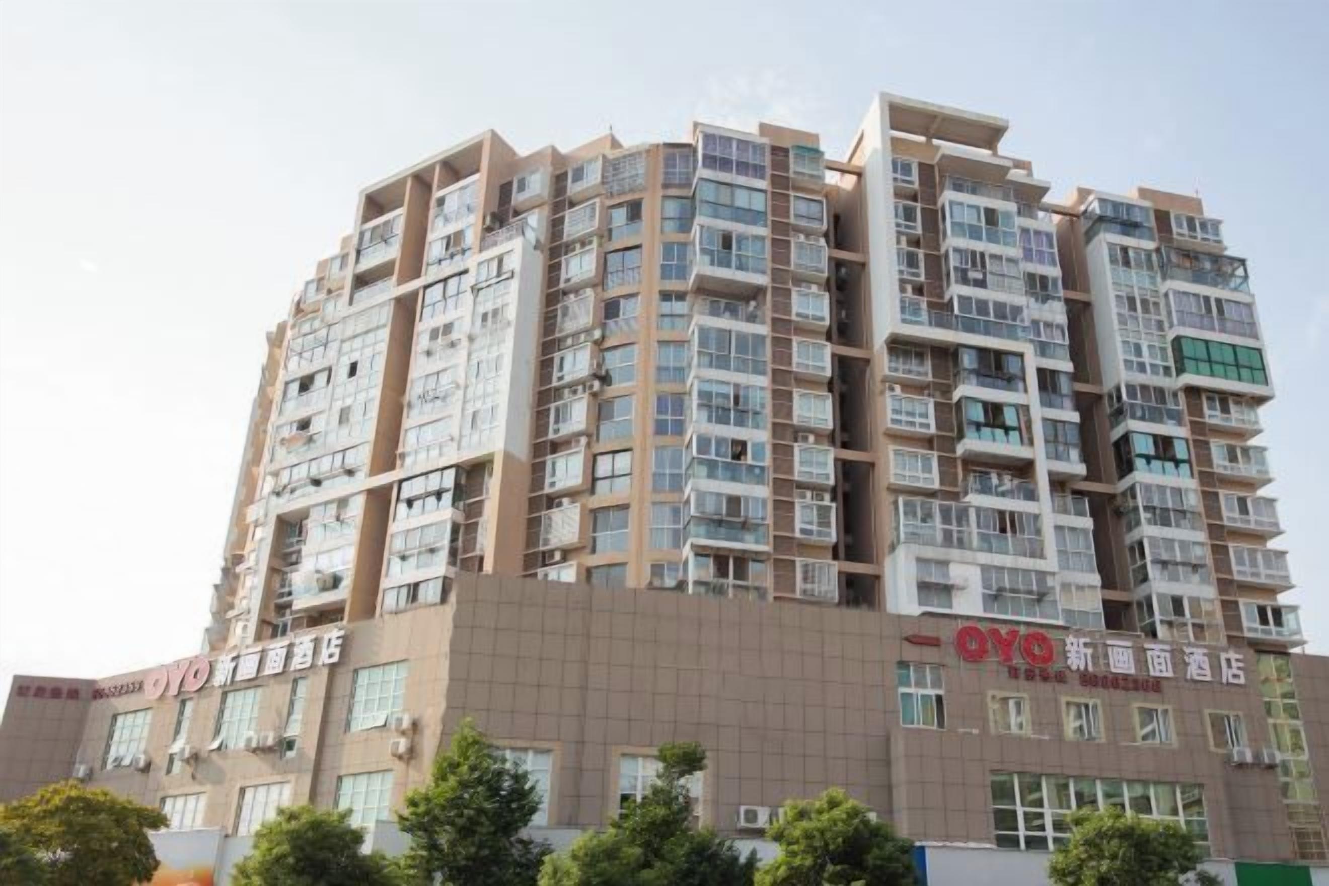 A multi-story hotel with a modern architectural design, featuring balconies and large windows.