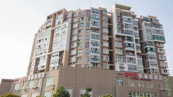 A multi-story hotel with a modern architectural design, featuring balconies and large windows.