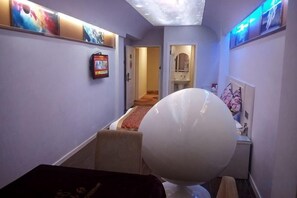 A hotel hallway with a bed, a television, and artwork on the walls. - Xinhuamian Fashion Hotel (Wenzhou)