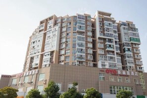 A multi-story hotel building with a modern architectural design, featuring numerous windows and balconies. - Xinhuamian Fashion Hotel (Wenzhou)