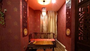 Una habitación tradicional con un banco de madera, una lámpara colgante y una puerta decorativa.