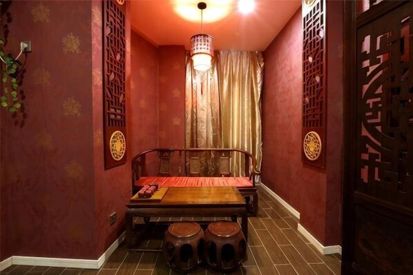 Una habitación tradicional con un banco de madera, una lámpara colgante y una puerta decorativa.