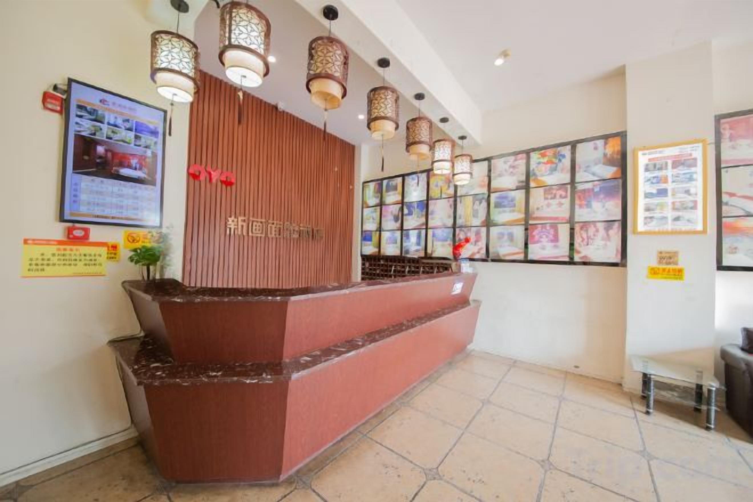 A reception area with a wooden reception desk, multiple framed pictures on the wall, and a tiled floor.