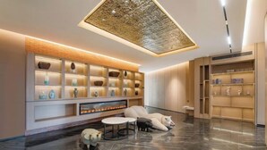 A modern interior with a fireplace, plush seating, and a decorative wall with shelves. - Yiwang Hotel Collection (Wenzhou Avenue) (Wenzhou)