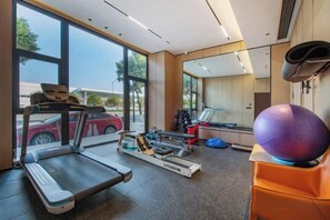 A gym with a treadmill, exercise ball, and weights. - Yiwang Hotel Collection (Wenzhou Avenue) (Wenzhou)