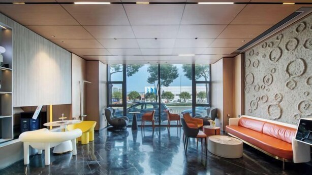A modern lobby with a seating area, a sofa, and a wall with circular patterns. - Yiwang Hotel Collection (Wenzhou Avenue) (Wenzhou)