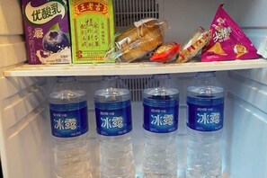 A refrigerator shelf with various food items and four bottles of water. - Yiwang Hotel Collection (Wenzhou Avenue) (Wenzhou)
