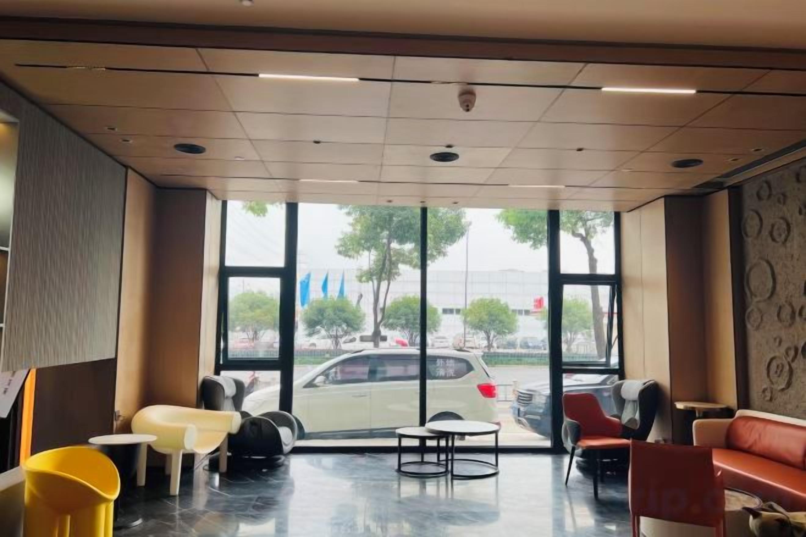 Un hall de hotel con zona de estar, ventanas amplias y vistas a la calle.