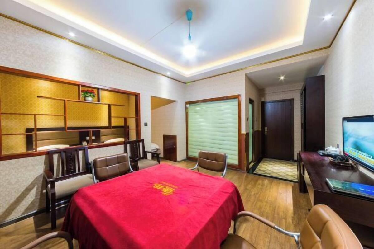 Une chambre d’hôtel comprenant un coin repas, un téléviseur et une porte donnant sur une autre pièce.