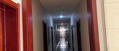 A hallway with doors on both sides, leading to rooms.