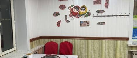 Una habitación con una mesa de comedor, sillas, una pared decorada y una ventana.