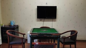 A room with a pool table, four chairs, a television mounted on the wall, and a small table with a kettle and other items. - Xiaohonglou Hotel, Luohe (Nehe)