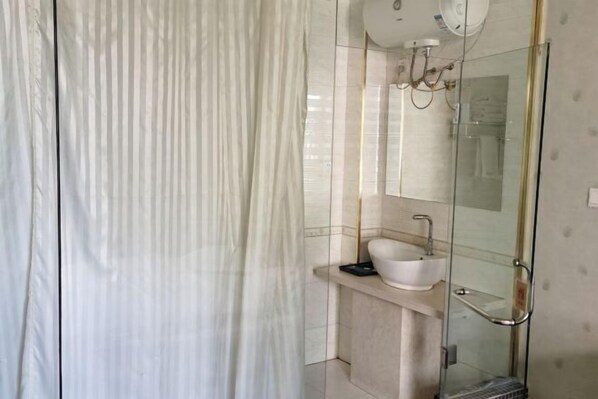 Une salle de bain moderne avec une douche à parois de verre, un lavabo blanc et un miroir au-dessus du lavabo.