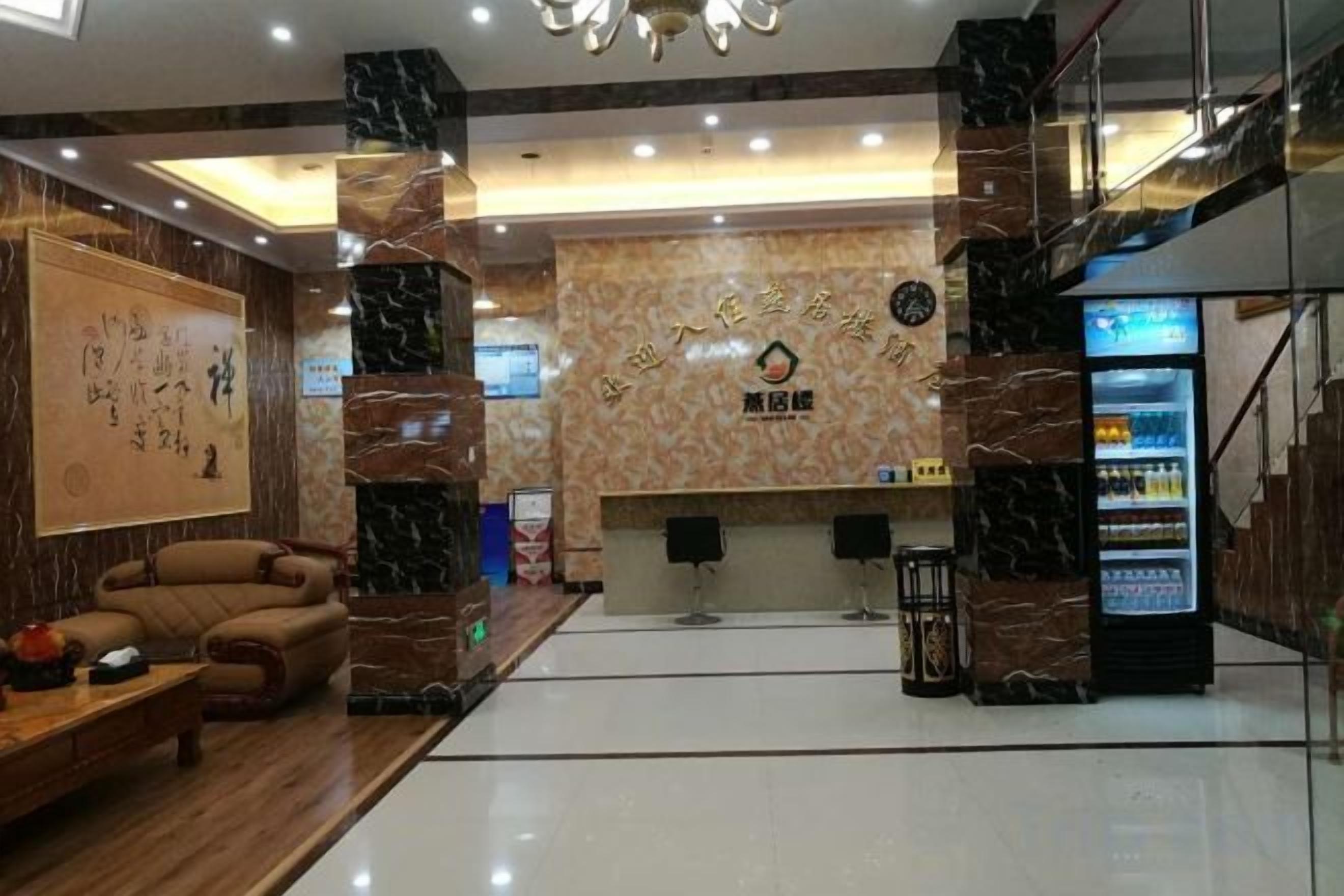 A hotel lobby with a reception desk, a seating area, and a vending machine.