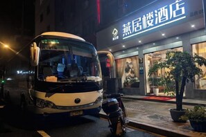 A bus parked in front of a hotel with a sign that reads 'Hotel'. - Hangzhou Yanjulou Hotel (Hangzhou)
