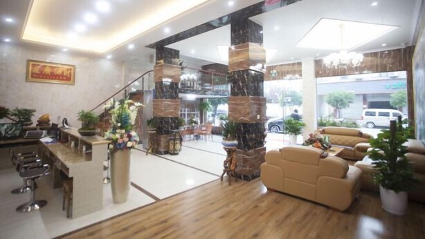 Eine Lobby mit Empfangsschalter, Sitzbereich und einer Treppe.