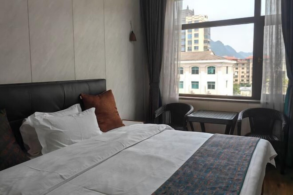 Una habitación de hotel con una cama, una mesita y una silla.