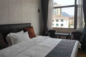 Una habitación de hotel con una cama, una mesita y una silla.