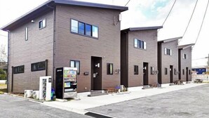A modern building with a flat roof, multiple windows, and a vending machine on the ground floor. - DUO ‧ OKINAWA (Onna)