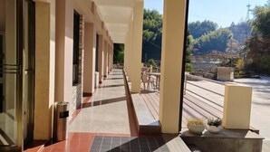 A covered walkway with a view of a mountainous landscape.