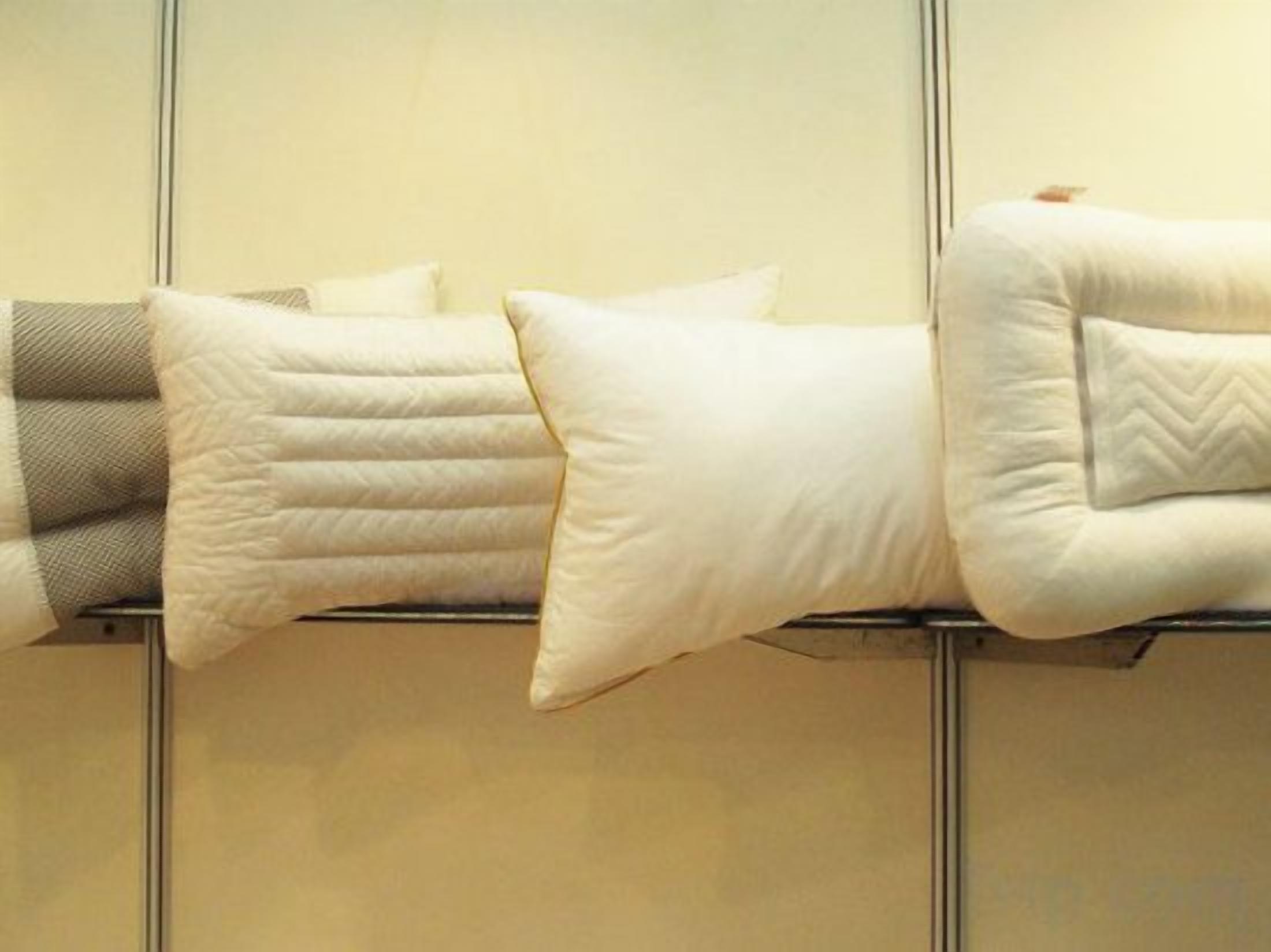 A bed with multiple pillows and a headboard.
