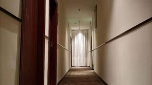 A narrow, well-lit hallway with wooden flooring and white walls. - Sunshine Express Hotel(Haikou international trade store) (Haikou)