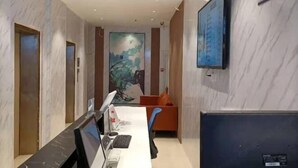 A modern office space with a long desk, computer, and a large painting on the wall. - Sunshine Express Hotel(Haikou international trade store) (Haikou)