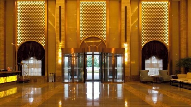 A spacious lobby with a polished marble floor, a reception desk, and a seating area with chairs and a sofa. - Fangte Dongxiang Hotel (Zhuzhou)