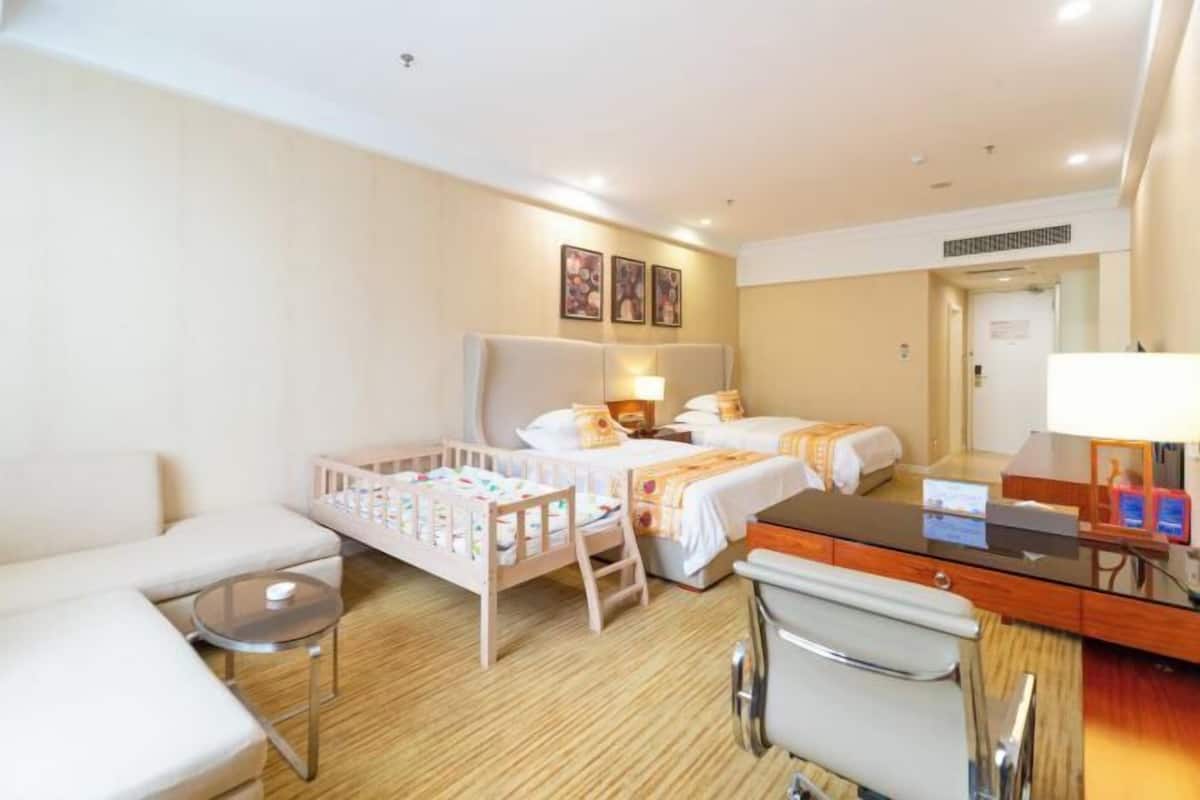 Une chambre d’hôtel avec un lit, un bureau, une chaise et une petite table.