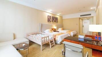 Habitación de hotel con cama, escritorio, silla y una mesita.
