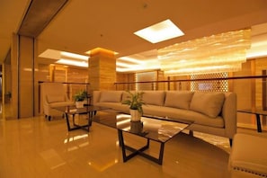 Een moderne lobby met een bank, fauteuils en een salontafel.