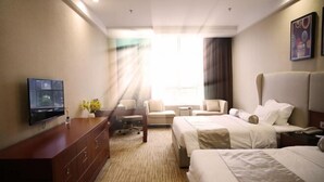 A hotel room with two beds, a desk, a chair, a TV, and a large window with curtains. - Fangte Dongxiang Hotel (Zhuzhou)