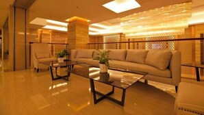 A modern living room with a sofa, armchairs, and a coffee table. - Fangte Dongxiang Hotel (Zhuzhou)