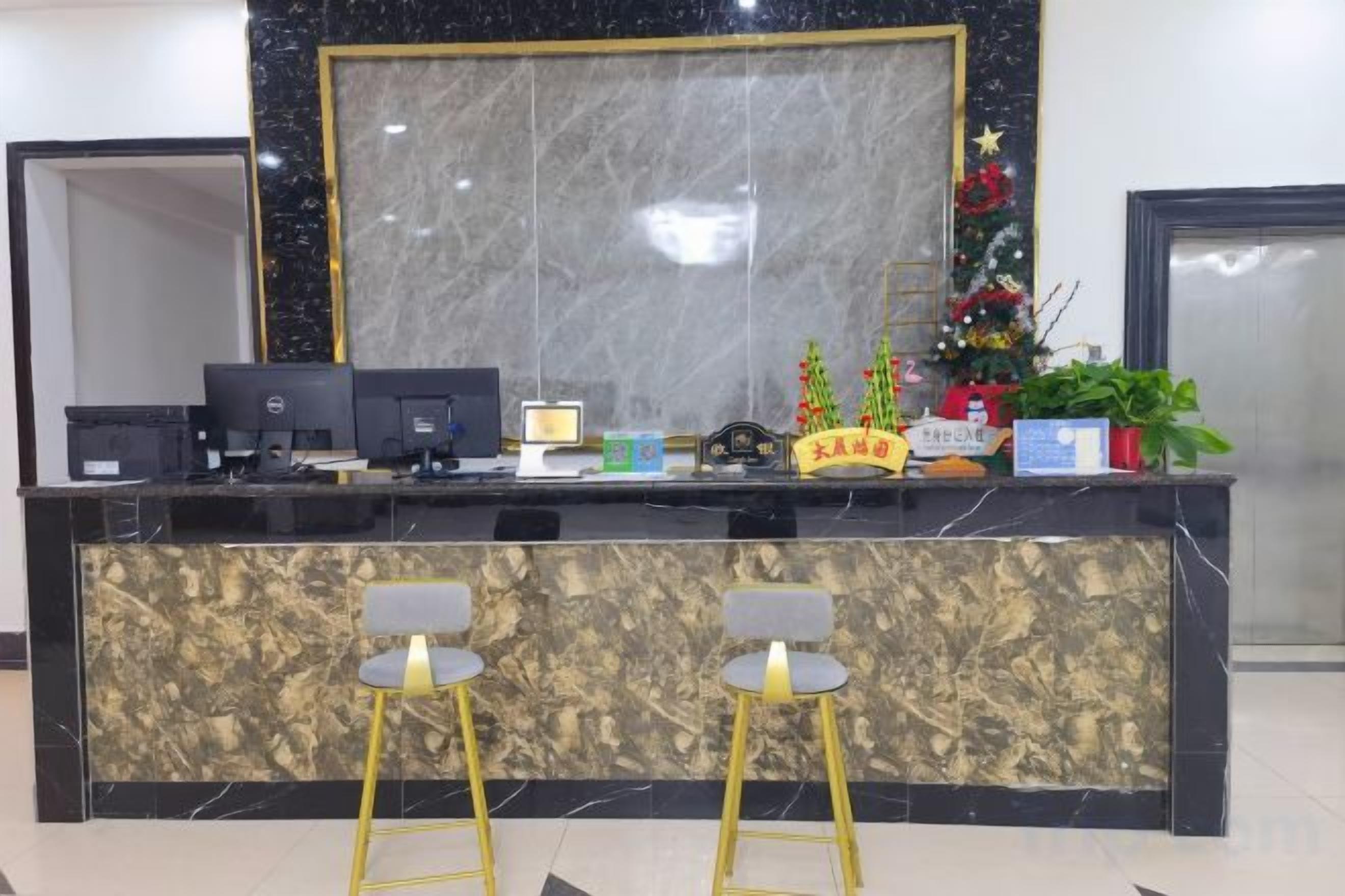 A reception desk with a computer, a small plant, and a decorative item.