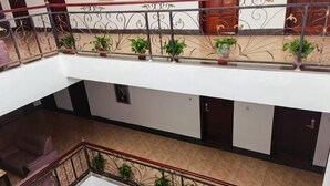 A multi-level interior with a balcony, potted plants, and a staircase. - Wenchang Ruyi Hotel (Wenchang)