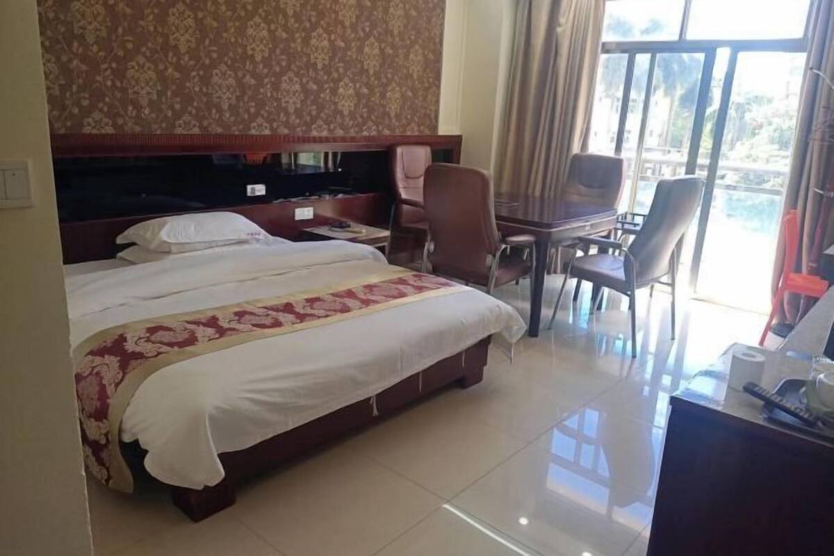 Ein Hotelzimmer mit einem großen Bett, einem Schreibtisch und einem Stuhl.