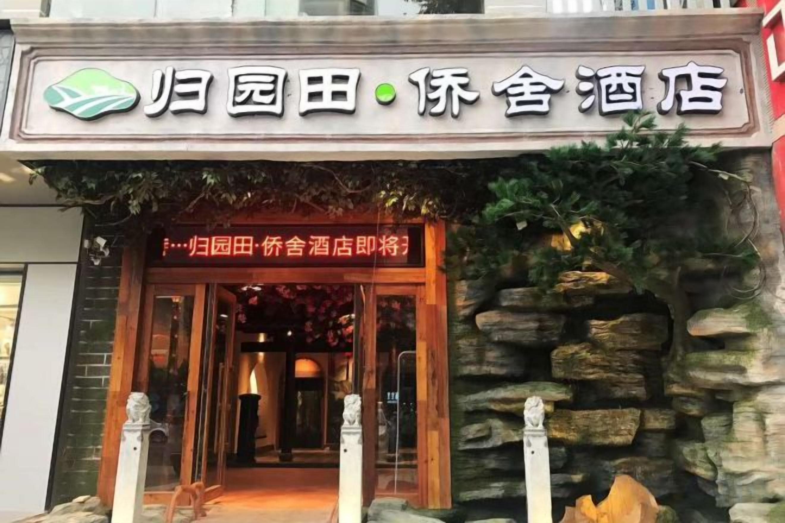 Ein Hotel mit steinverkleideter Fassade und einem Schild über der Tür.