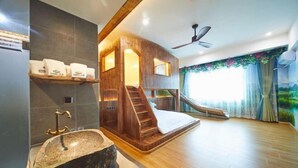Una spa con una vasca da bagno in pietra, una scala in legno e un ventilatore a soffitto.