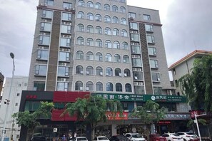 Un edificio de varios pisos con una planta baja comercial, con letreros de diferentes negocios.
