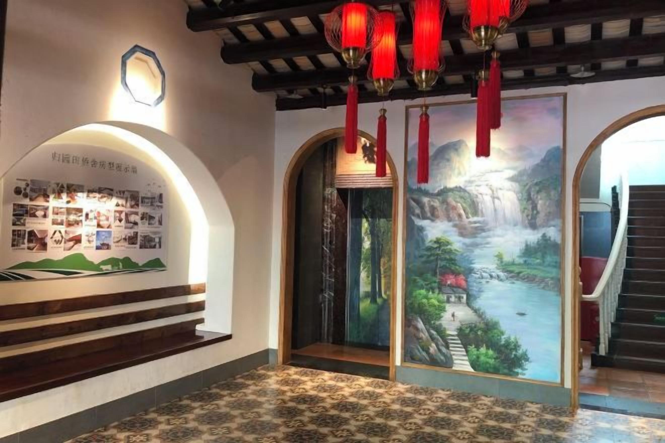 Um saguão com um mural, uma escadaria e uma parede com painéis informativos.