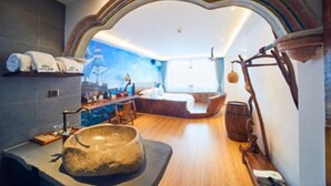 Un bagno moderno con un lavandino in pietra, elementi in legno e vista sulla città.