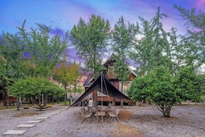 A lodge with a wooden structure, outdoor seating, and a gravel path. - Sun Holiday Resort (Changxing)