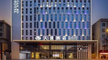 A modern hotel building with a prominent sign for the Tian Bo Hotel.