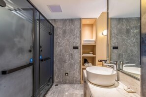 A modern bathroom with a glass shower enclosure, a freestanding bathtub, and a large mirror. - Tian Bo Hotel (Qianwei County)